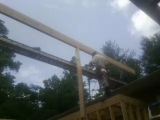 Carpenter setting a ridge beam over a new addition frame — Ice Dam Removal by Roofing Brothers in Erwinna