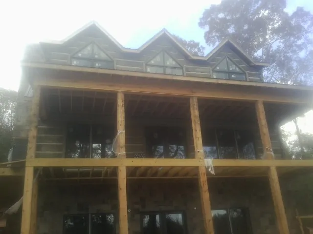 Dormers and porch framing on a large log home under construction — Roof Coating work by our crew in Erwinna