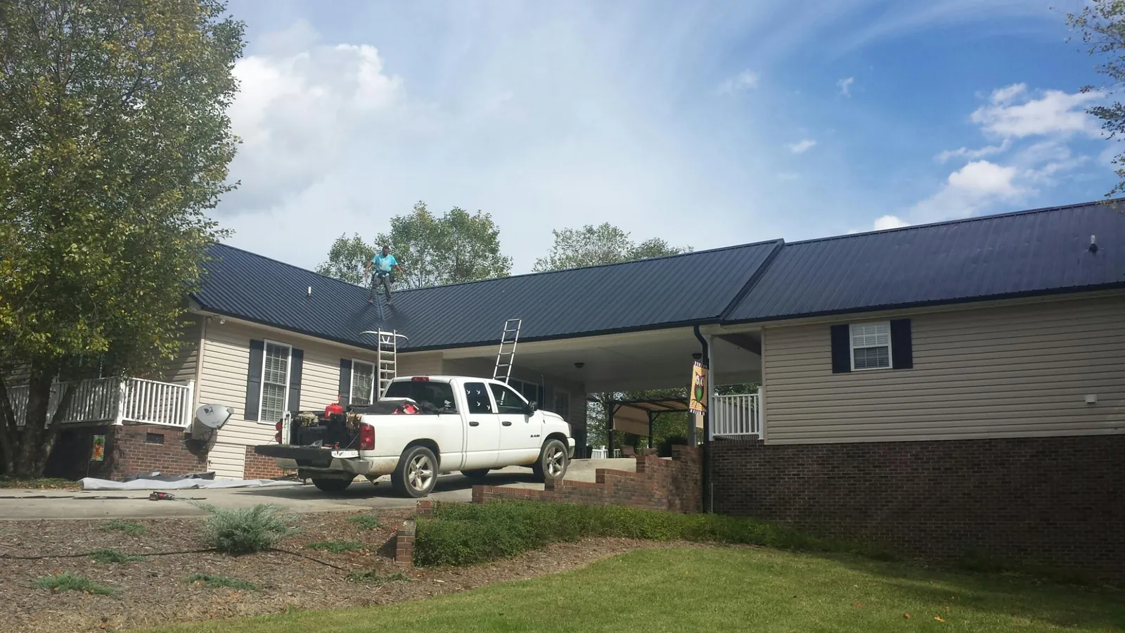 Black metal roof over a home and attached breezeway with ladders set in Erwinna