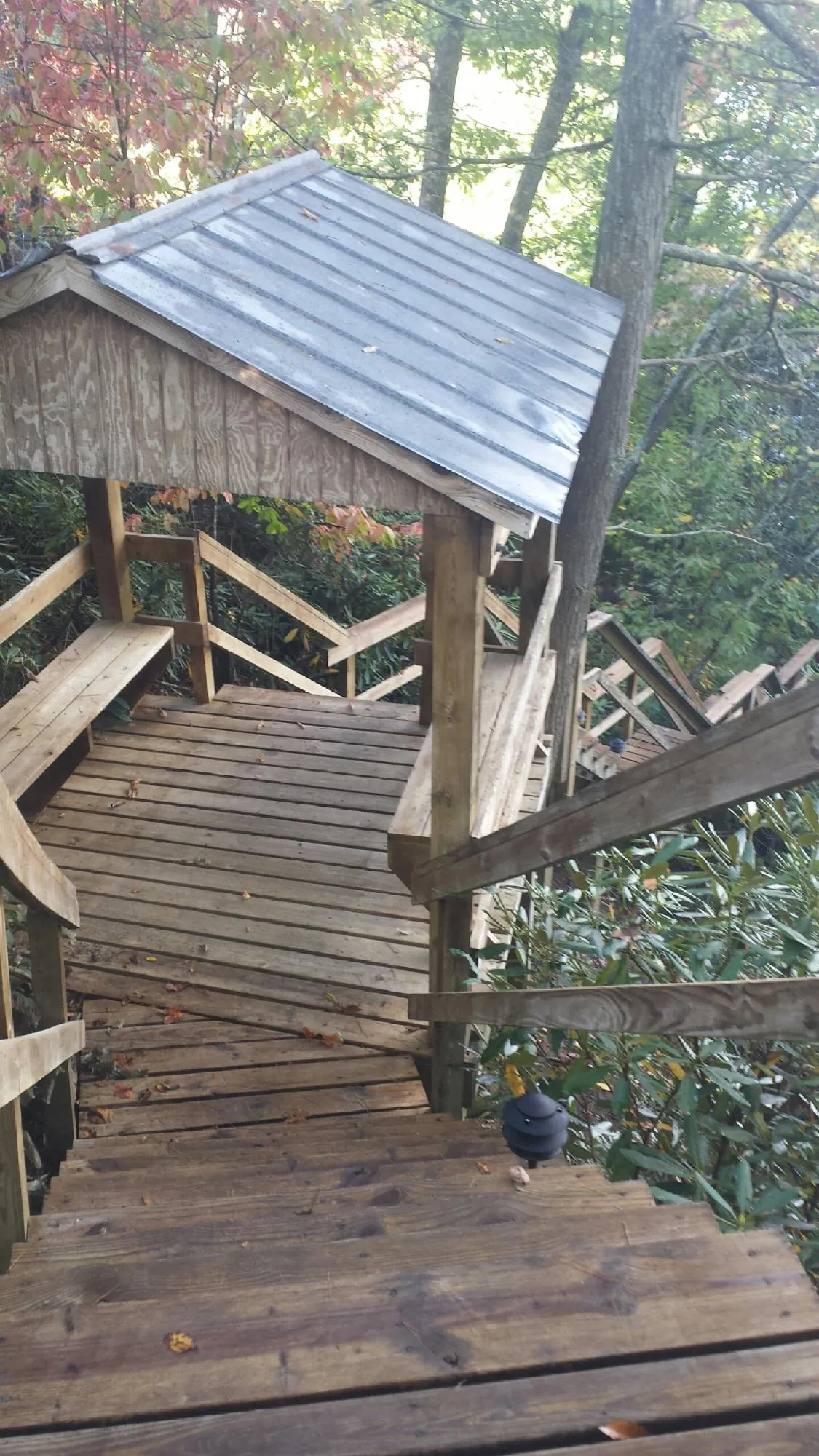 Metal roofed shelter over wooden steps on a wooded walkway — Skylight Repair & Installation work by our crew in Erwinna